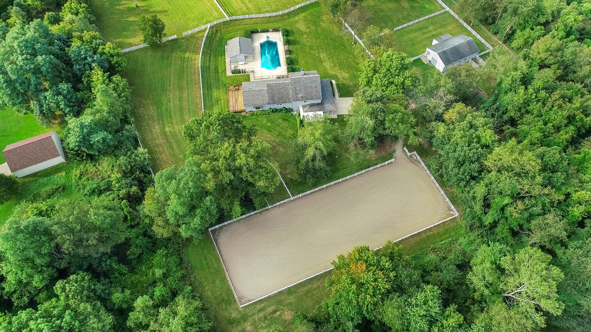 Aerial view of a home and riding arena among trees in Wayne County