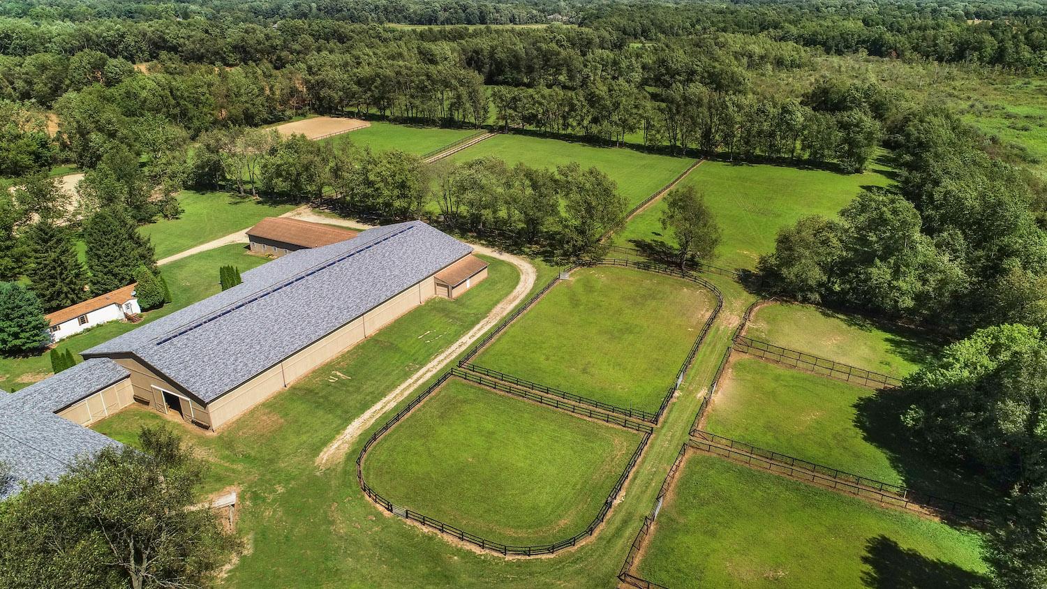 Aerial view of a horse barn and fenced paddocks in Calhoun County
