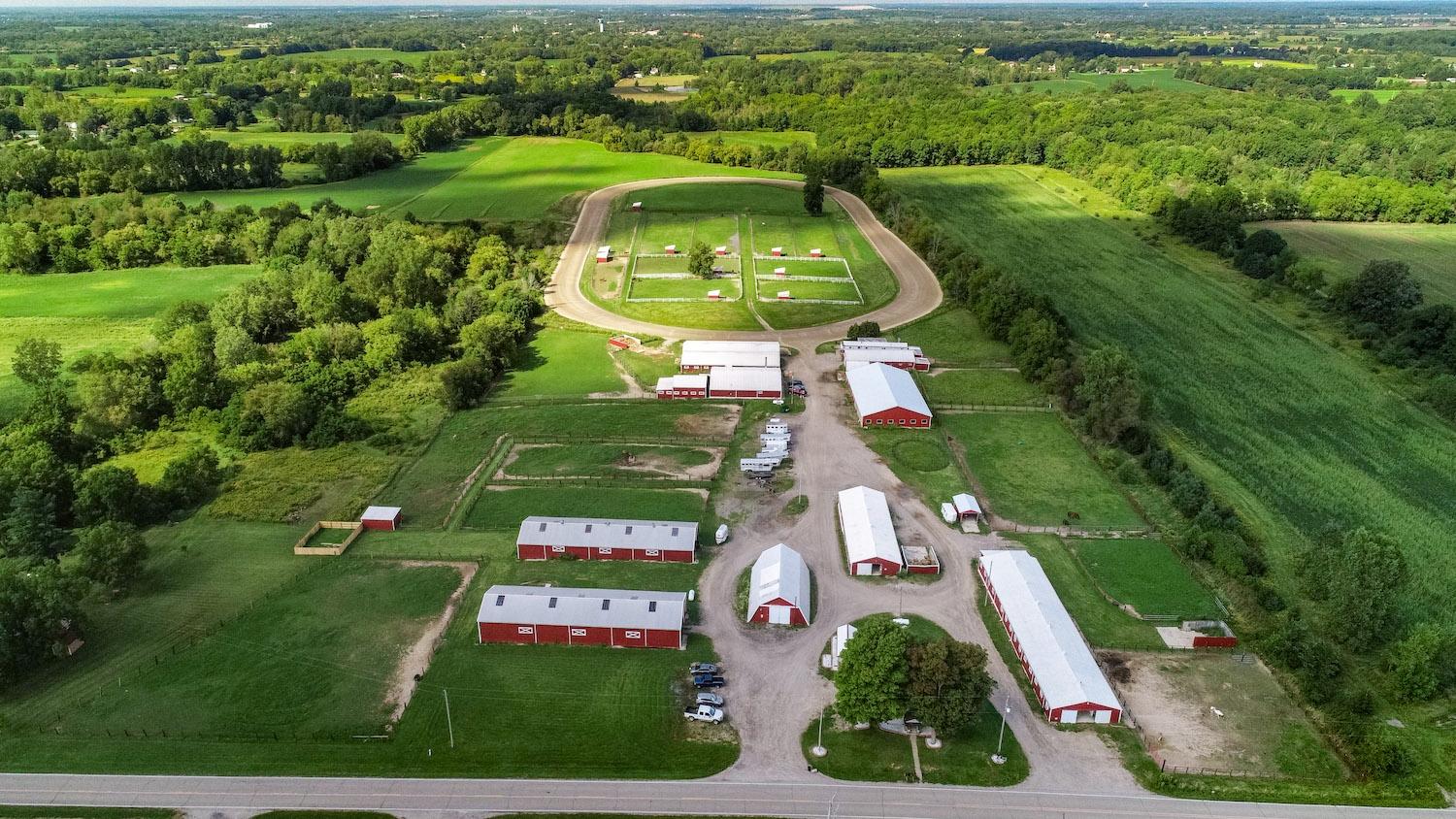 Aerial view of a horse farm with barns and pastures in Shiawassee County