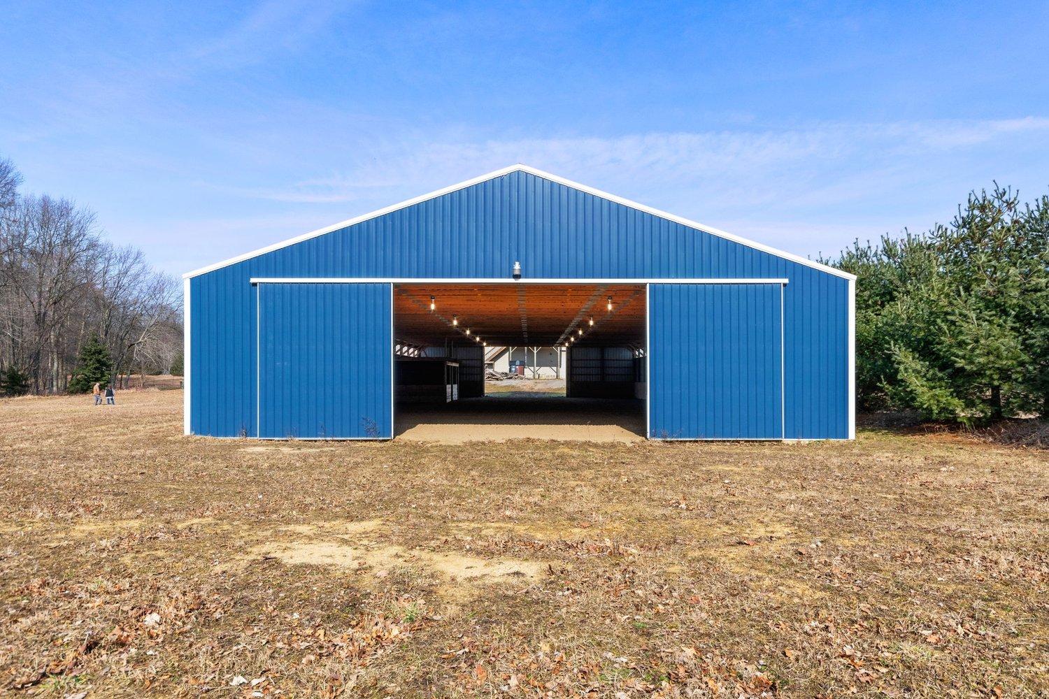 Large blue horse barn with open doors in Jackson County