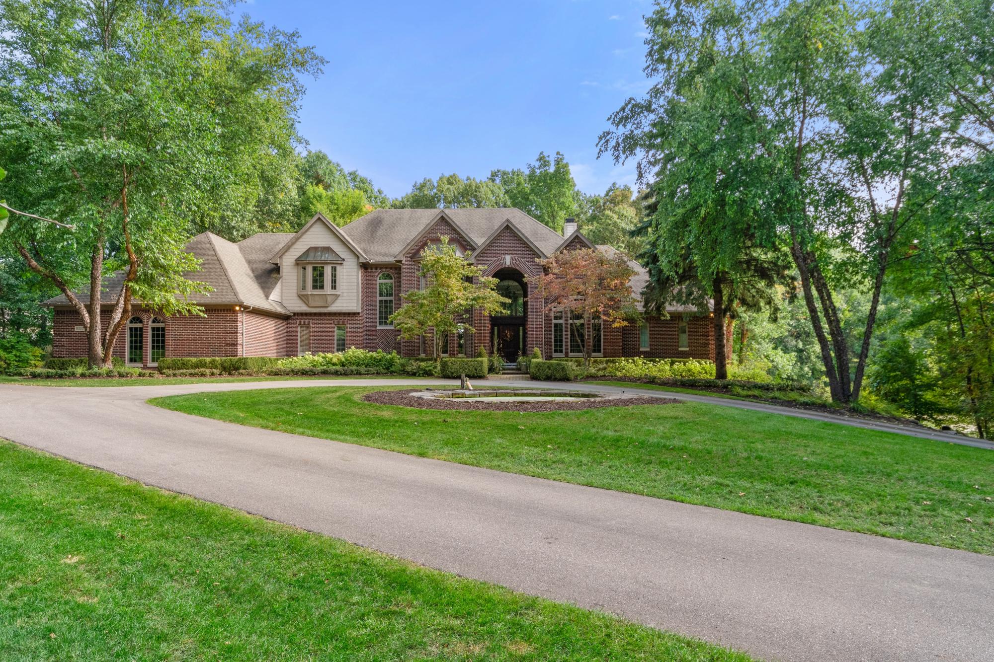 Brick estate home with a long paved driveway in Davisburg