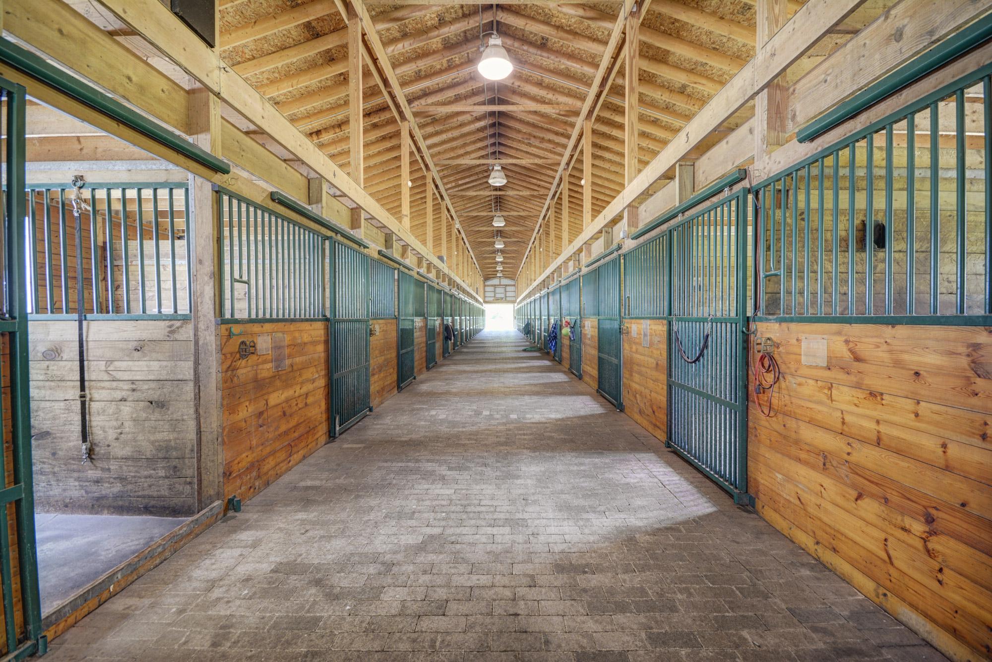 Horse barn aisle lined with wood stalls in Oakland County