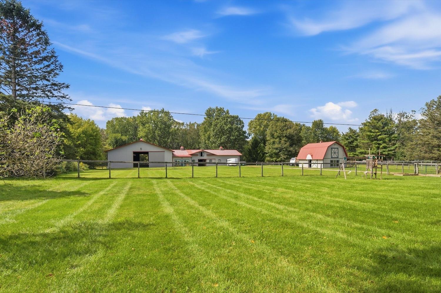 Fenced pasture and horse barns at 9623 Earhart Rd in South Lyon